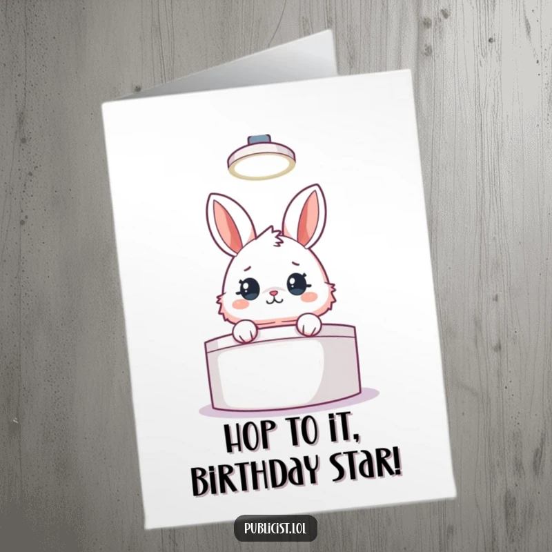 Funny free printable birthday card featuring a fluffy rabbit peeking from behind a podium, spotlight on, ready for their big moment.